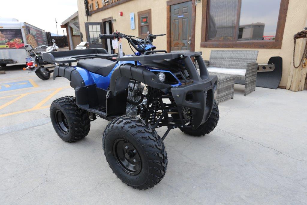 A blue and black atv parked in front of a building.