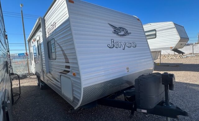 A white trailer parked in the middle of a lot.