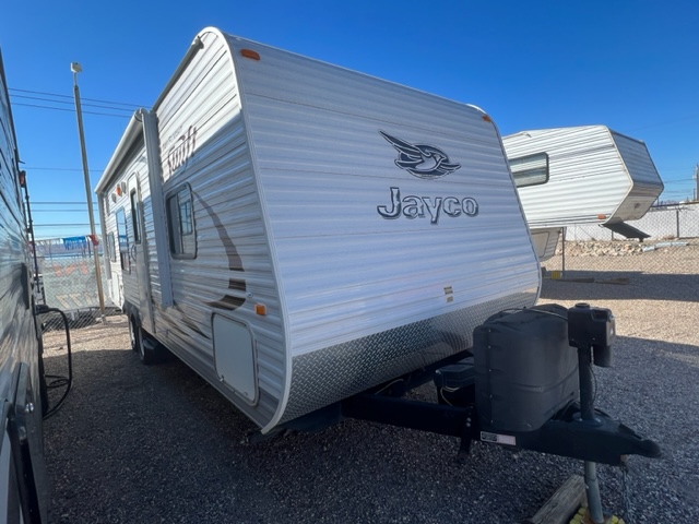 A white trailer parked in the middle of a lot.