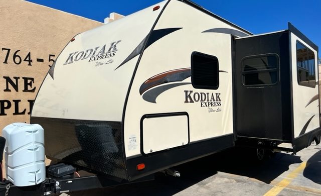 A white and black trailer parked in the parking lot.