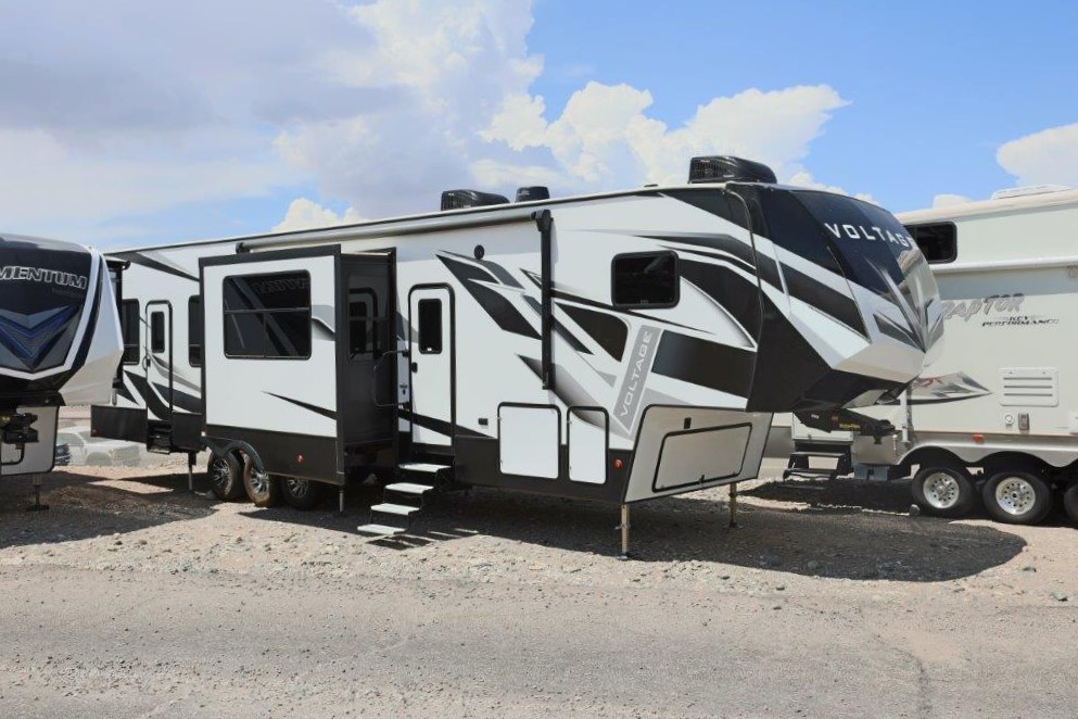 A black and white rv parked on the side of a road.