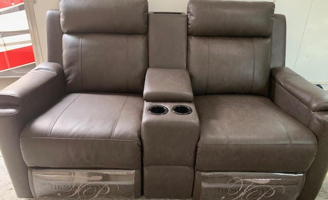 A couch with two recliners and a cup holder.