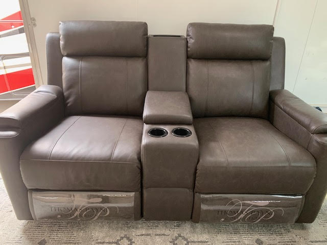 A couch with two recliners and a cup holder.