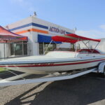 A boat is parked in front of the action one store.