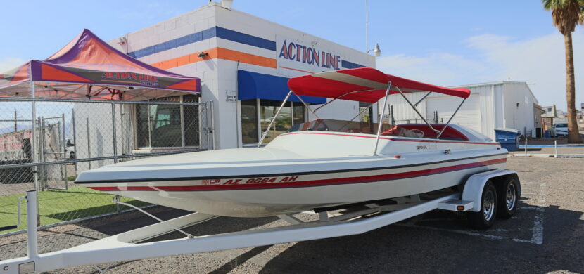 A boat is parked in front of the action one store.