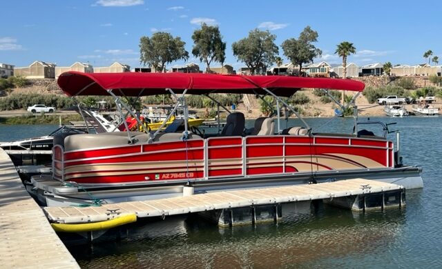 A red boat is docked at the dock.