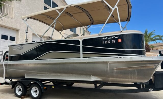 A boat is parked in the street under an awning.