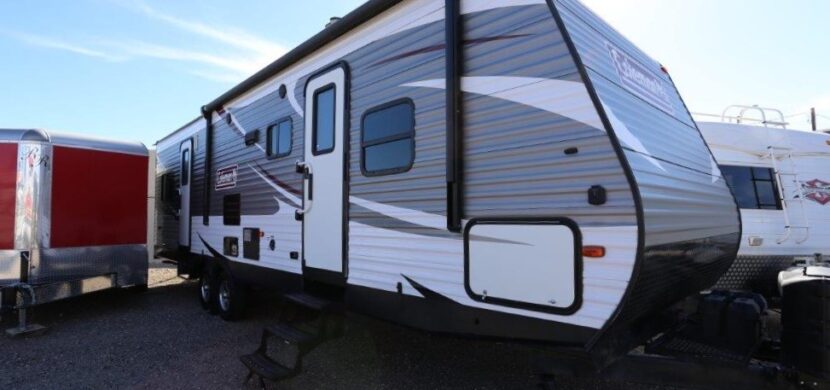 A trailer parked in the dirt with a sky background