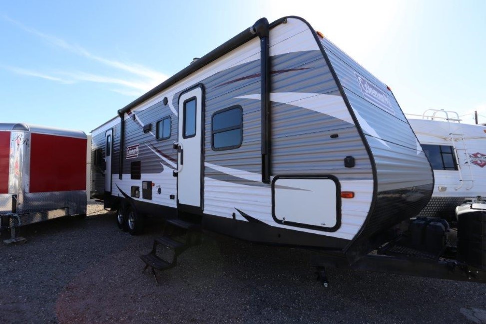 A trailer parked in the dirt with a sky background