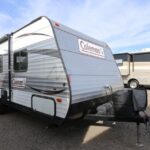 A white camper trailer parked in the parking lot.