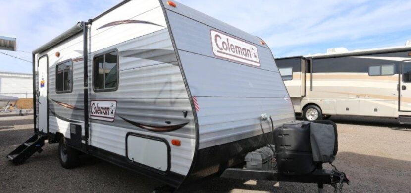 A white camper trailer parked in the parking lot.