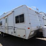 A white rv parked in the middle of nowhere.