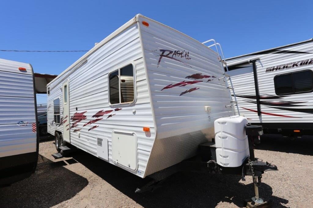 A white trailer with red and black accents parked in the lot.