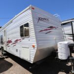 A white trailer with red and black accents parked in the lot.