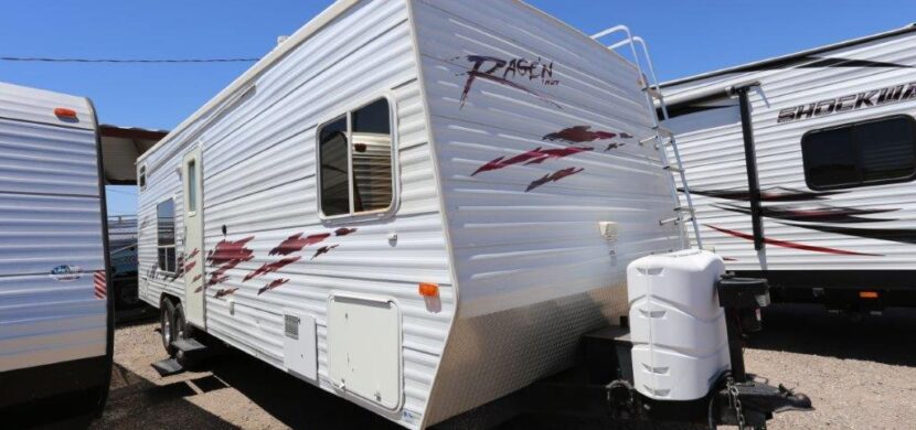 A white trailer with red and black accents parked in the lot.