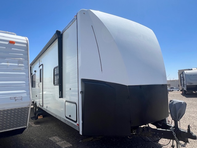 A white and black trailer parked in the sun.